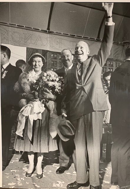 President Eisenhower waves to the crowd, standing next to his wife Mamie.