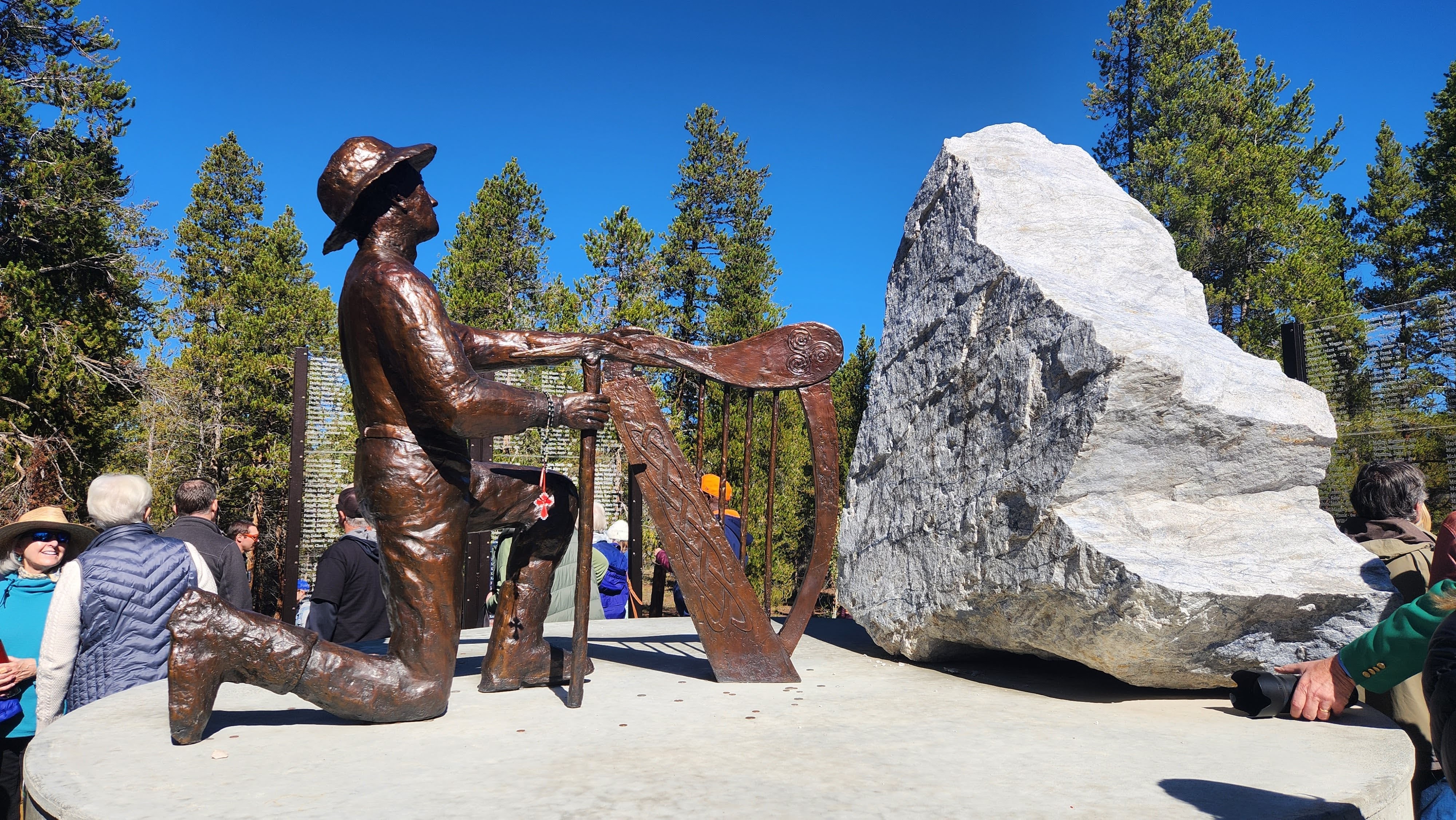 A perspective of the centerpiece of the Leadville Miners' Memorial, which depicts a man with a pick, kneeling at an Irish harp.