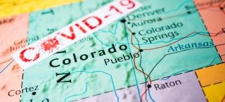 Map of Colorado with "COVID-19" text across it
