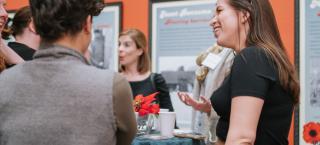 Visitors gather around a table and join in conversation