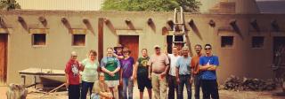 Volunteers in front of adobe building