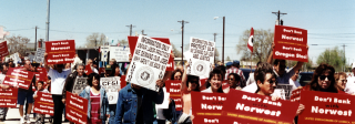 A marching protest of Pueblo steelworkers and supporters. They carry signs reading "Don't Bank with Northwest. Don't Bank on Oregon Steel."