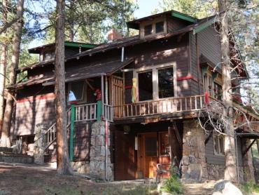 An image of the VIncent-Hatchette cabin, a rustic style building clad in stone and horizontal wood shake and board siding.