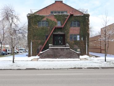 View of the Scott Apartments, a two and a half story red brick building with climbing ivy on its walls.