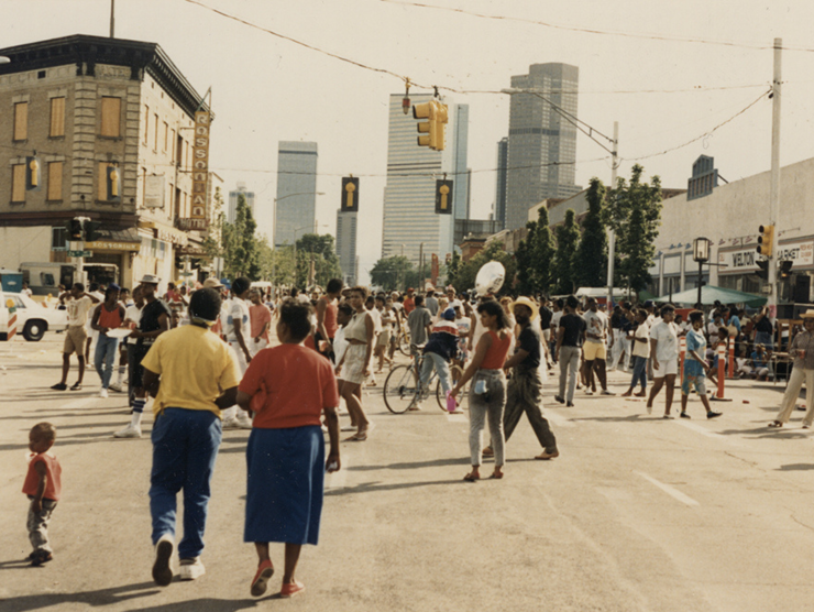 Historic color photo of people on a street with the Blaxplanation series logo superimposed